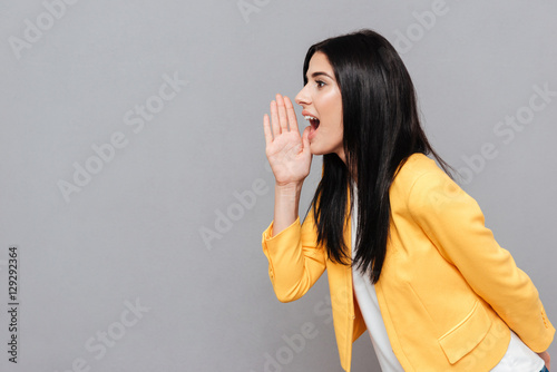 Woman shouting over grey background