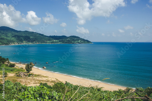 Sea shore with sandy beach and blue sky. Vacation in Vietnam landscape.