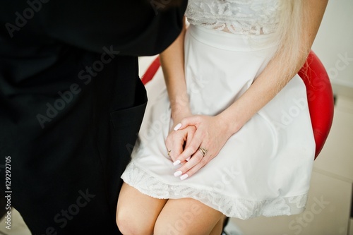 Gentle hand with ring of young bride in white dress, make up process