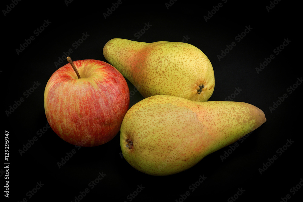 Φωτογραφία Apple of red color and two pears of yellow color on a black back