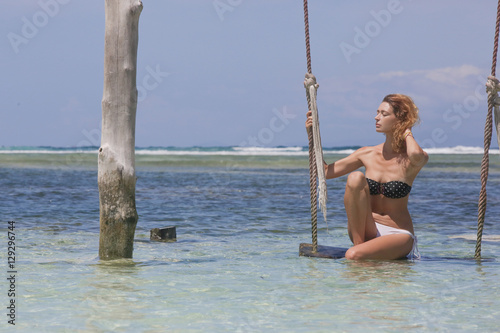 Woman swinging at tropical beach 