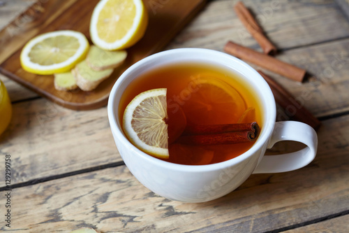 White cup of black natural tea with ginger, lemon and honey. Healthy Antiviral drink. Hot winter useful beverage concept.
