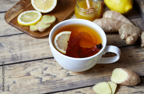 Antiviral ginger tea with lemon,honey and ginger slice on wooden background. Healthy drink. Rustic style. Creative composition.
