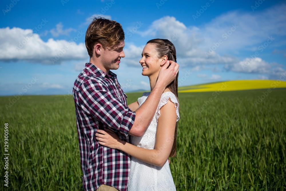 Romantic couple embracing each other in field Romantic couple embracing each other in field