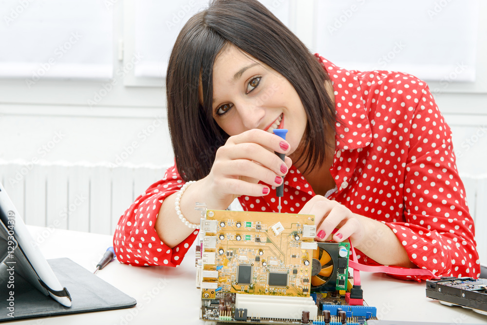 brunette woman technician repairs a computer brunette woman technician repairs a computer