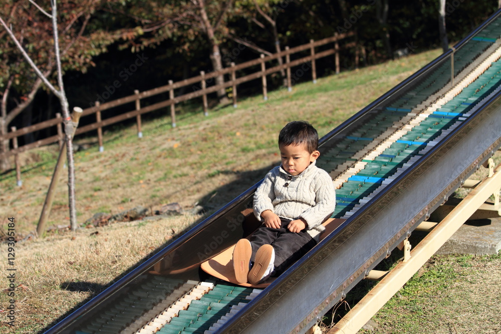 Fototapeta premium 滑り台で遊ぶ幼児(3歳児)