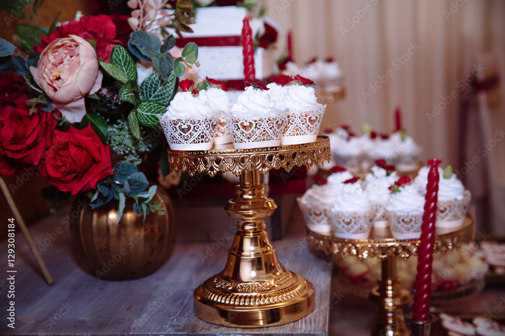 Candy bar, red colour, marsala. Table with wedding cake, sweets, candies, dessert, pops.