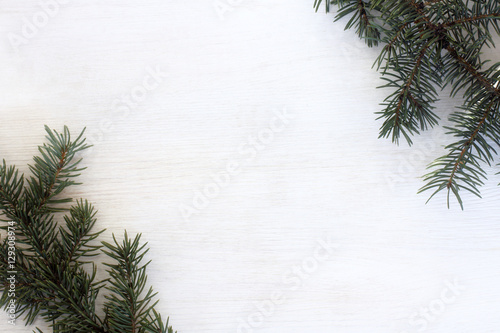 winter holiday decoration/ nature spruce branches on a light wood surface top view 
