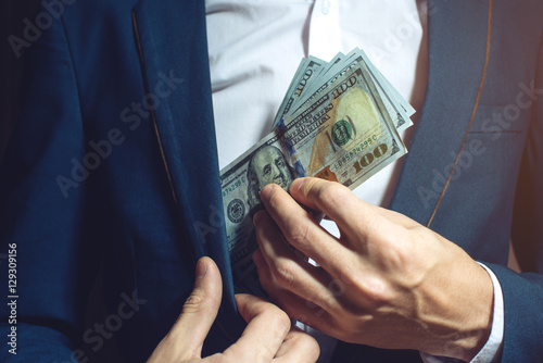 фотографія man businessman taking notes in pocket as a bribe