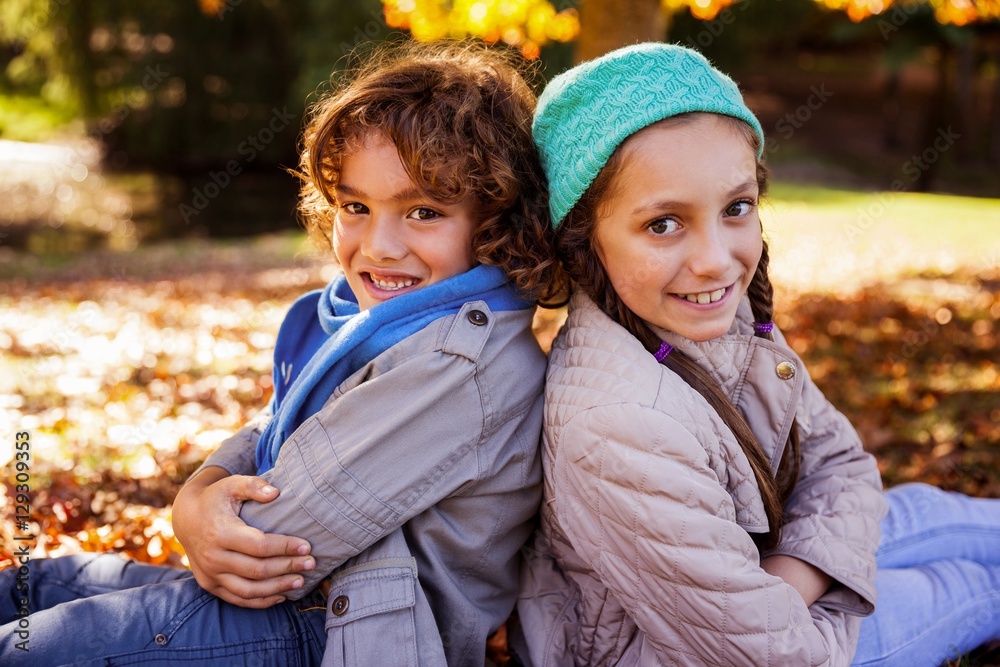 Portrait of smiling siblings with arms crossed in park Portrait of smiling siblings with arms crossed in park