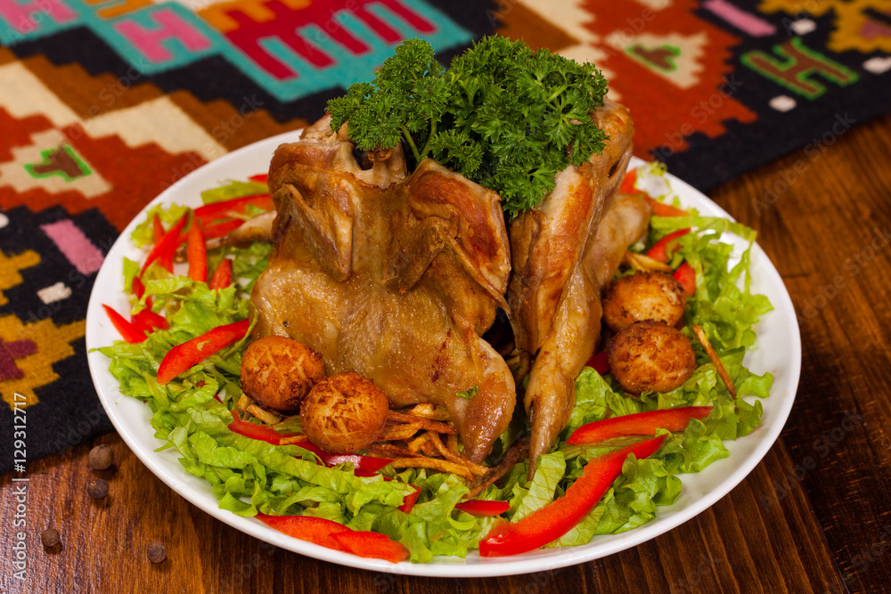Chicken Tabaka with parsley, potatoes and lettuce on a white plate Chicken Tabaka with parsley, potatoes and lettuce on a white plate