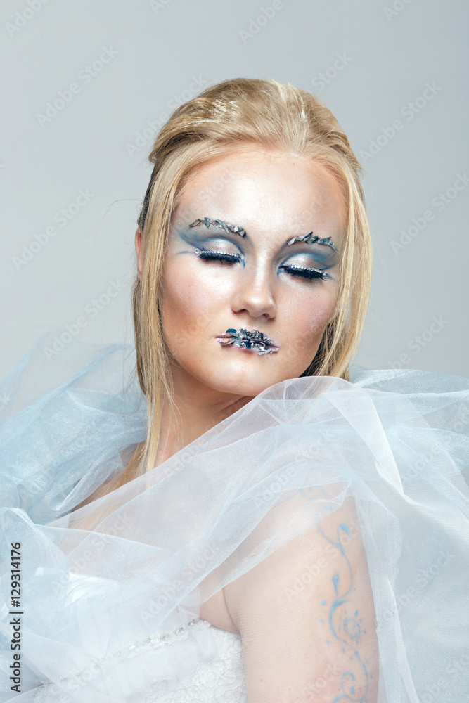 blonde in a white dress with blue makeup. The Snow Queen. blonde in a white dress with blue makeup. The Snow Queen.