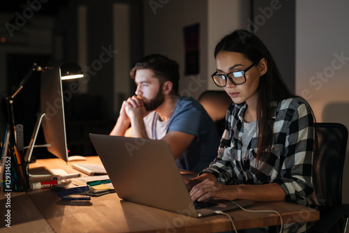 Business people working with laptop and computer late at night photo