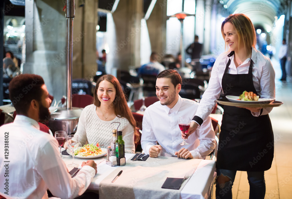 Obraz premium Smiling friends in outdoors restauran