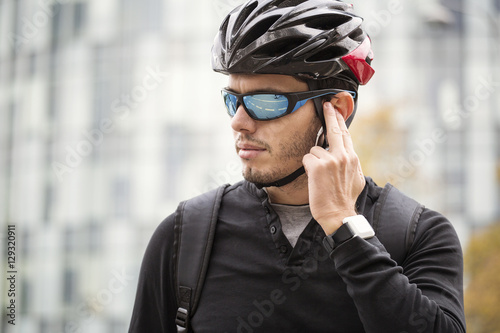 Man with his bike preparing to ride, with high builind in backgr photo