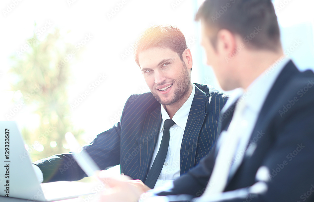 Fototapeta premium Two businessmen discussing tasks sitting at office table.