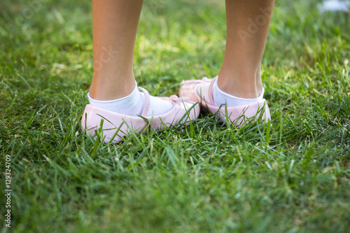 Child's pink shoes in a green grass