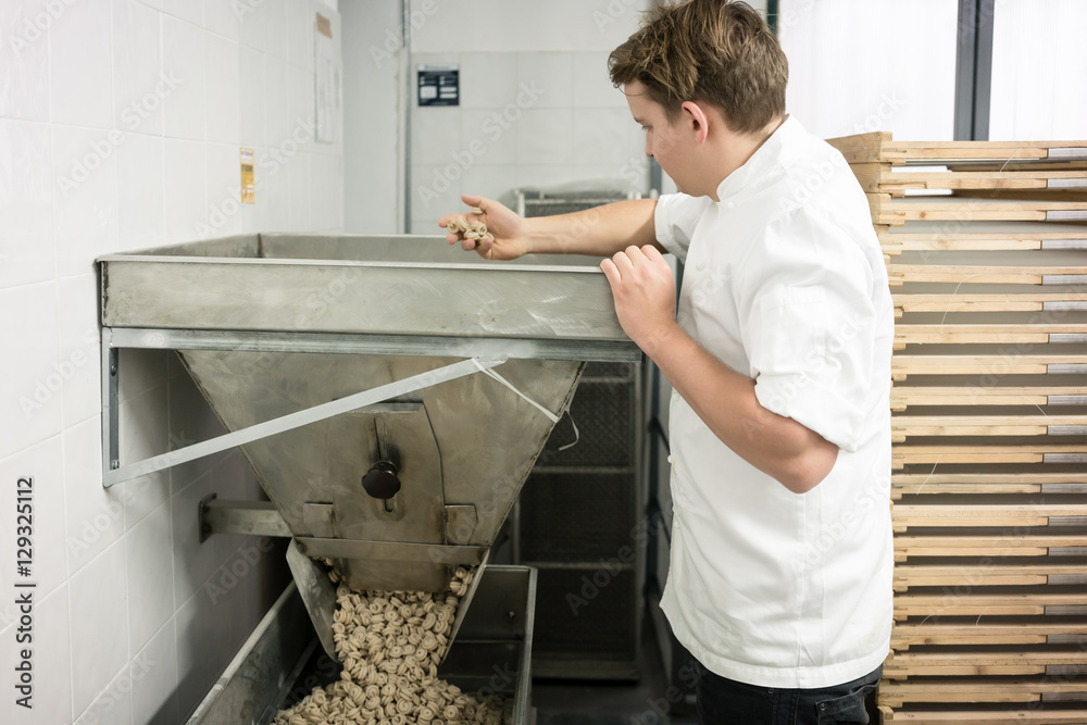 Chef inspecting the manufacturing of noodles in Italian pasta fa