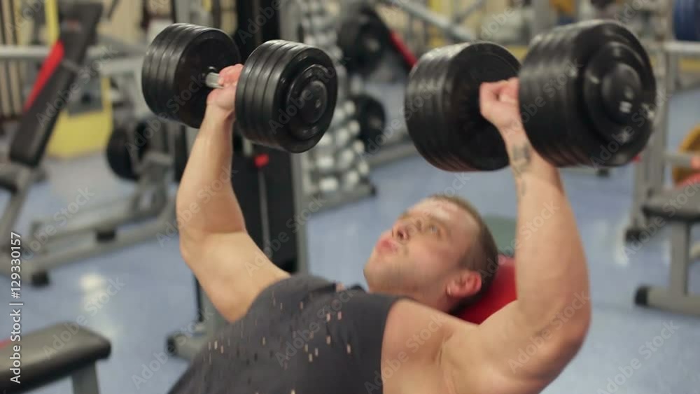 Bodybuilder performing chest press with dumbbells. Chest training. Bodybuilder performing chest press with dumbbells. Chest training.