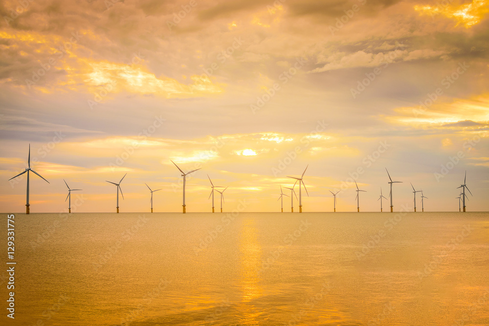 Sunset Offshore Wind Turbine in a Wind farm under construction off the coast of England.