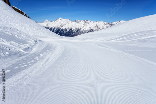Snowcat prepared Aibga snowy mountain cirque ski slope in Krasnaya Polyana ski resort