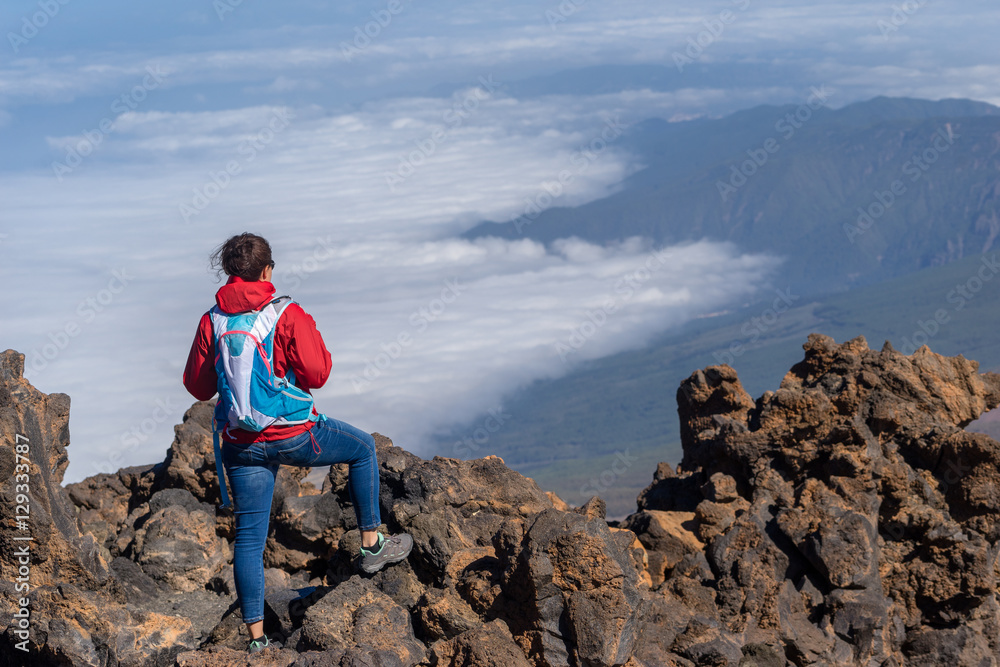 Female hikers enjoying scenic view of Teide National Park, Tenerife, Canary Island. Hiking high above clouds in 3000 meter above sea level.