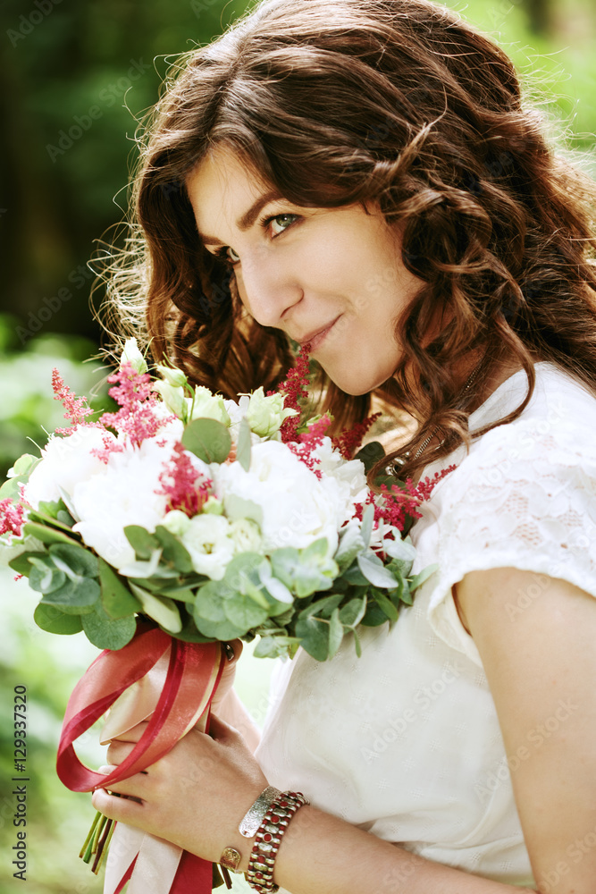 Young smiling bride with wedding flowers Young smiling bride with wedding flowers
