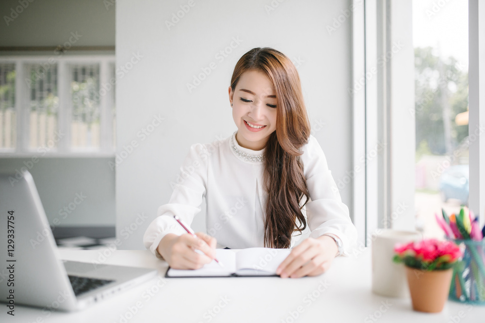 indoor picture of smiling Asia woman with notebook and pen indoor picture of smiling Asia woman with notebook and pen