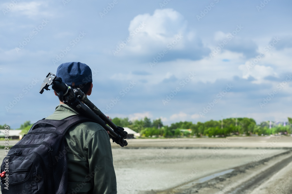 Young traveler wearing a cap with backpack and tripod Young traveler wearing a cap with backpack and tripod