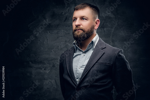 Portrait of middle age bearded male dressed in a wool grey suit.