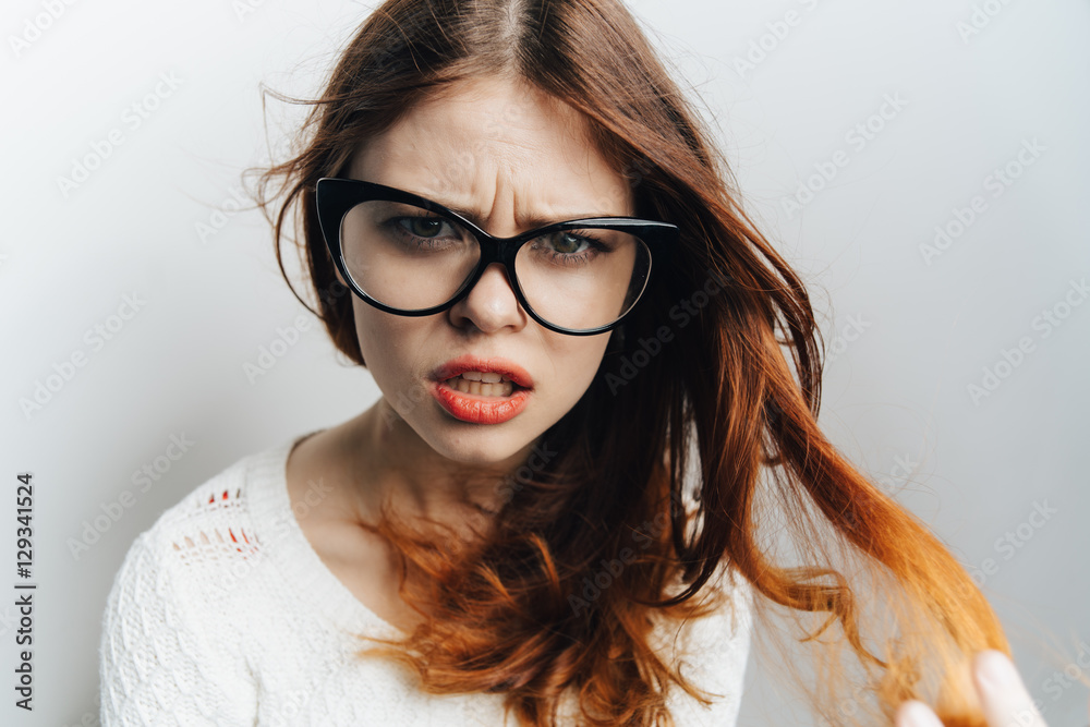 Portrait of a girl in glasses on a light background
