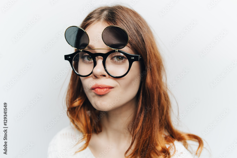Portrait of a girl in glasses on a light background
