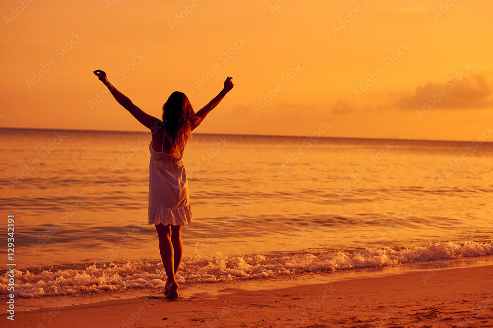 Woman enjoying freedom on a sunset beach