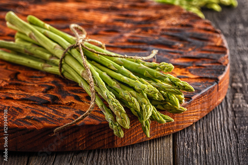 Fresh asparagus on the wooden background.