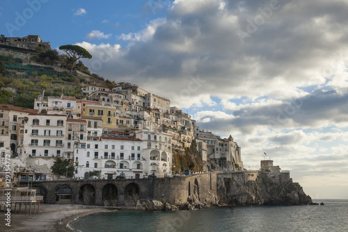 Postcard view of the beautiful town of Amalfi in the morning light. Gulf of Salerno, Campania, Italy. Blue sky background with clouds