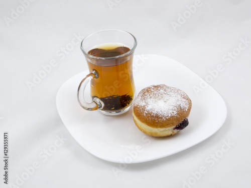 Transparent Cup with Tea and a Donut