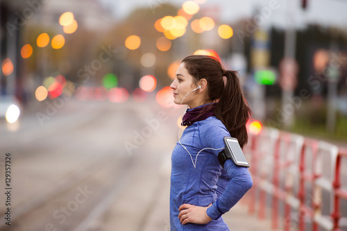 Young woman in blue sweatshirt running in the city