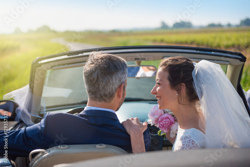 young couple is going on honeymoon  by car on a country road © jackfrog