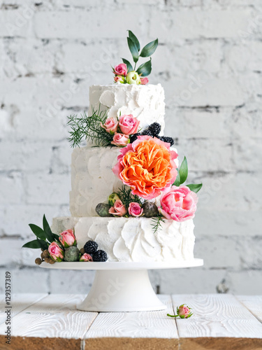 White wedding cake with flowers and blueberries