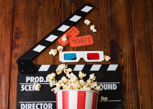 Movie clapper, popcorn, 3d glasses on a wooden