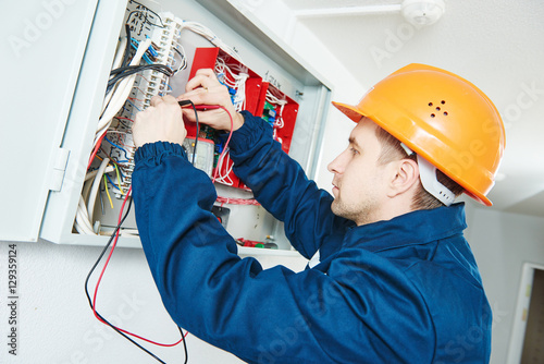 electrician examining current voltage with screwdriver tester photo