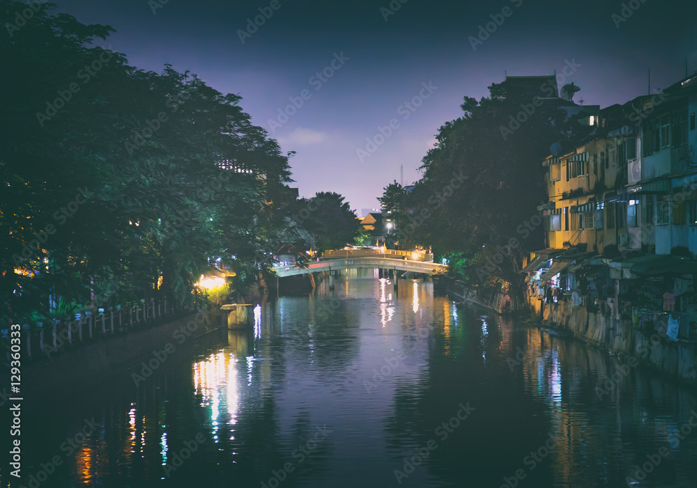 Night landscape of Klong Ong Ang canal in touristic center of Bangkok, Thailand. Night illumination of buildings and bridges.