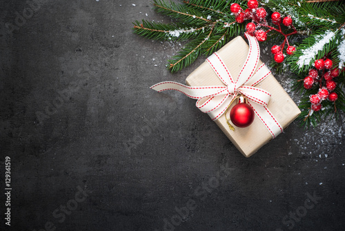 Christmas gift, tree branch, decorations on slate background.