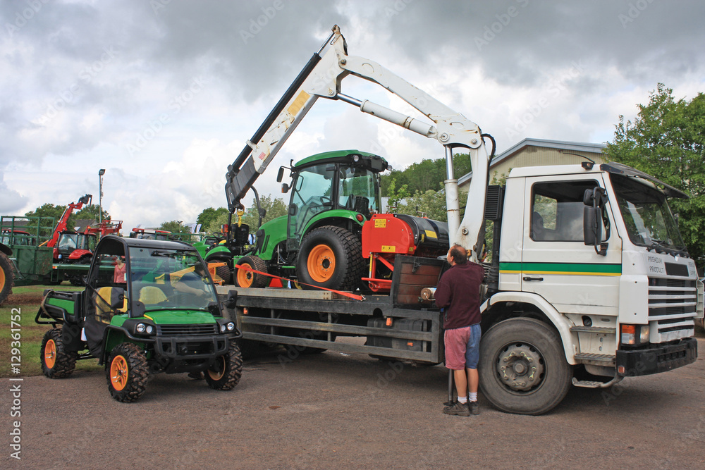 Tractor being loaded on a truck