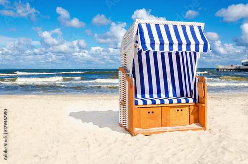 Blue and white wicker chair on sandy beach