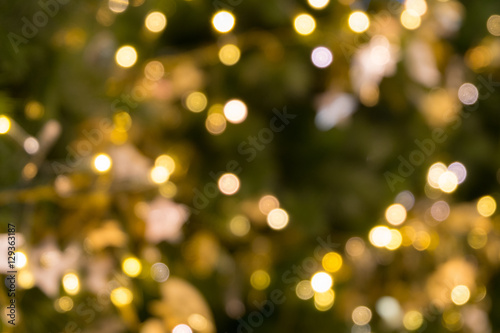 christmas tree bokeh light in green yellow golden color, holiday abstract background, blur defocused