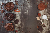Selection of roasted coffee beans, dark chocolate and spices on a rustic background