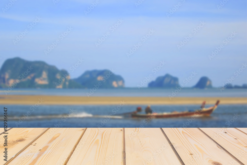 Wooden board empty table in front of blurred background. Perspective brown wood over sea with fisherman on boat while sailing boat for mock up display or montage your products, vintage.