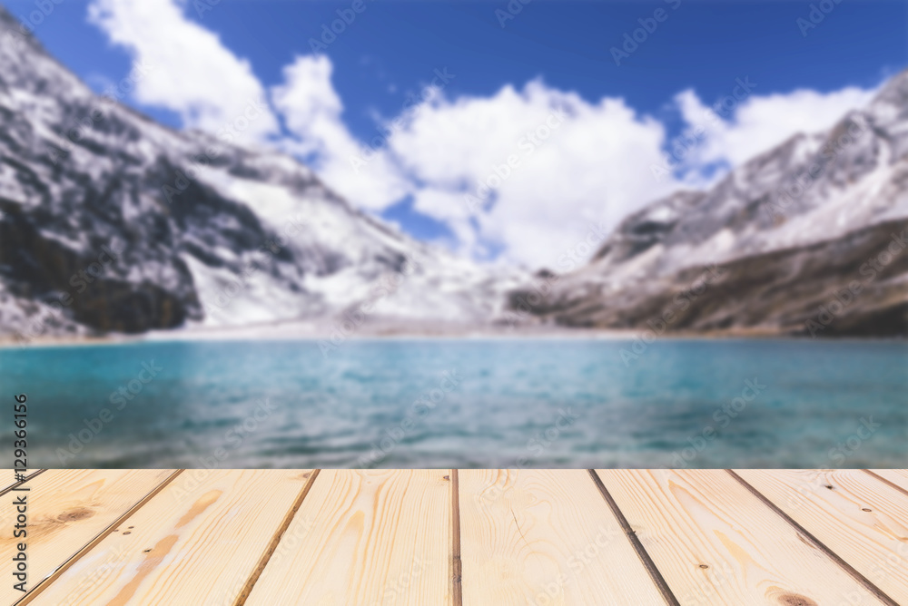 Wooden board empty table in front of blurred background. Perspective brown wood over lake in snow mountain for mock up  display or montage your products, vintage. 