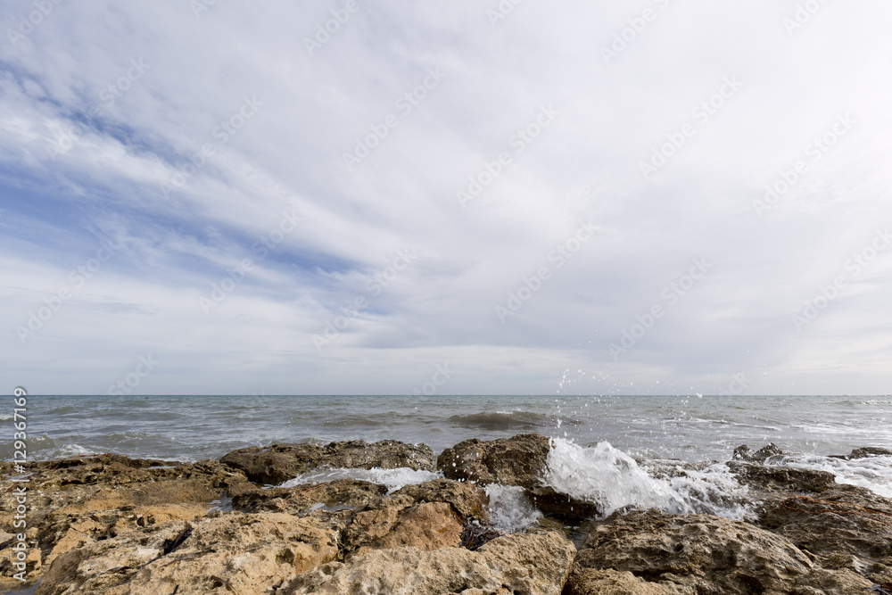 Rocky beach with waves in Santa Pola, Alicante province, Spain.